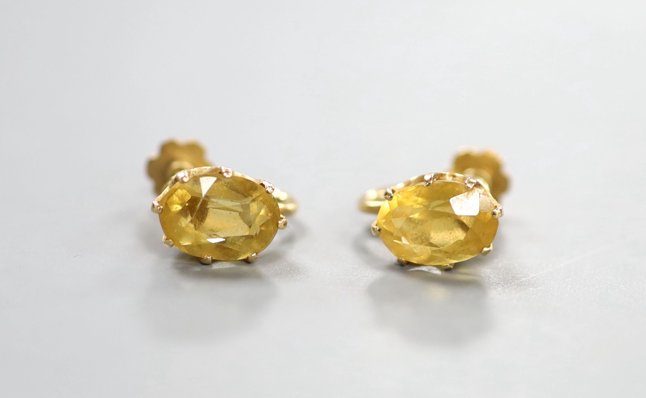 A pair of yellow metal and oval cut citrine set ear clips, 11mm, gross weight 5.7 grams.